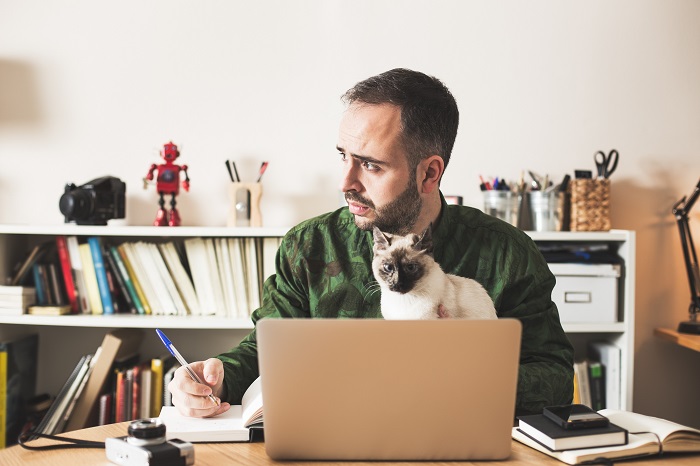 Мужчина с котом за ноутбуком